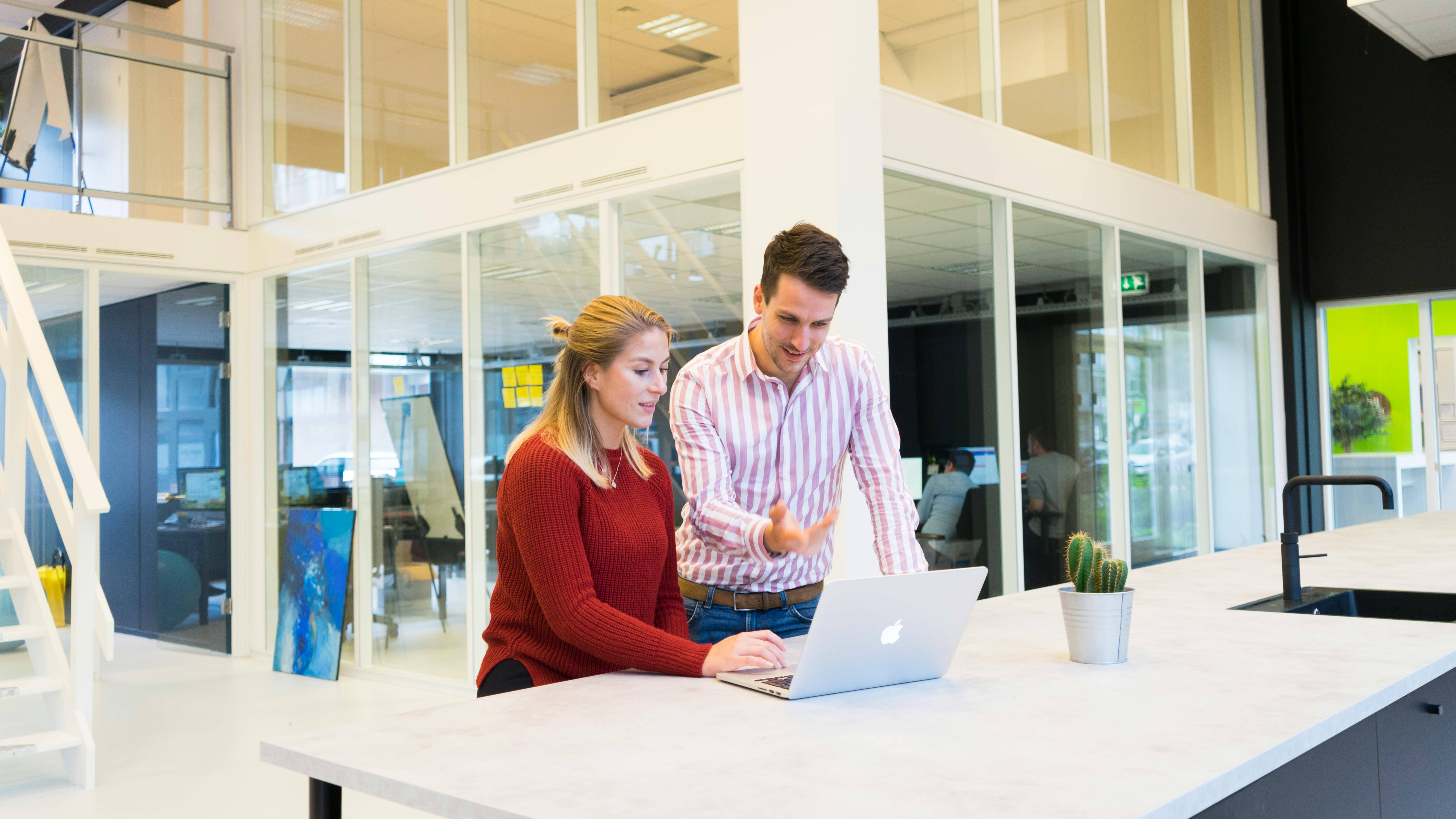 Two colleagues around a laptop