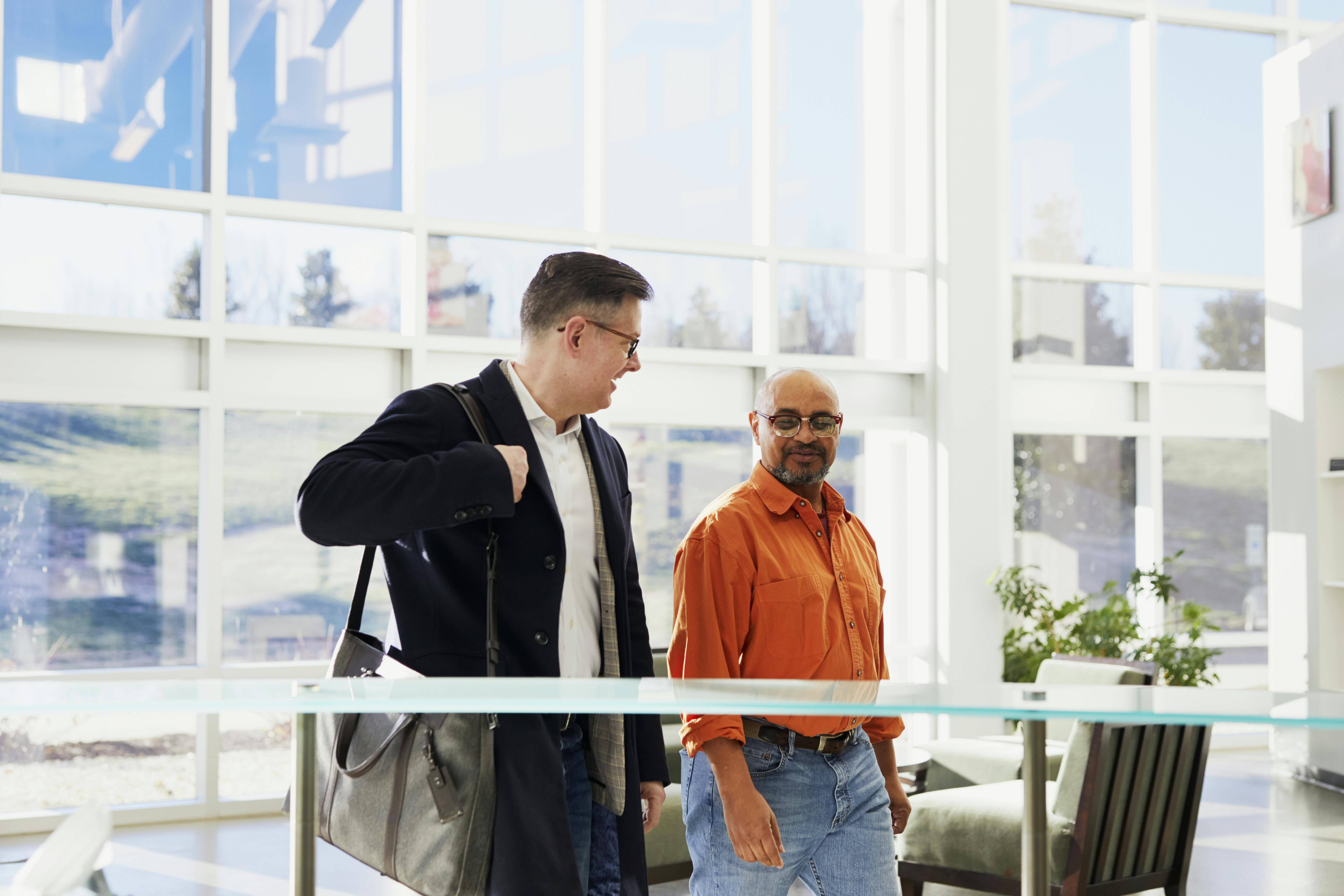 Two colleagues walking into an office