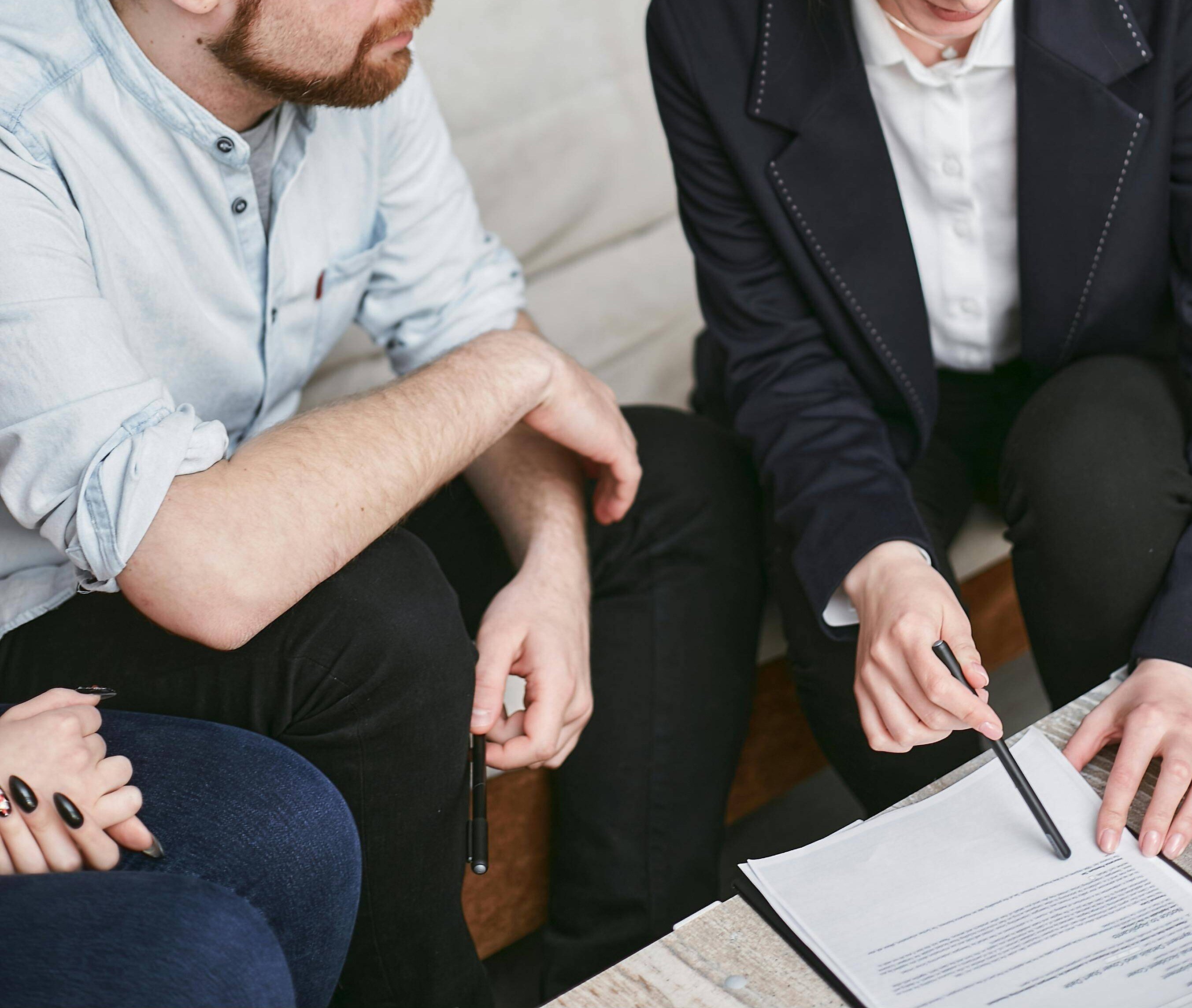 Woman dressed in business attire going through a document with a man