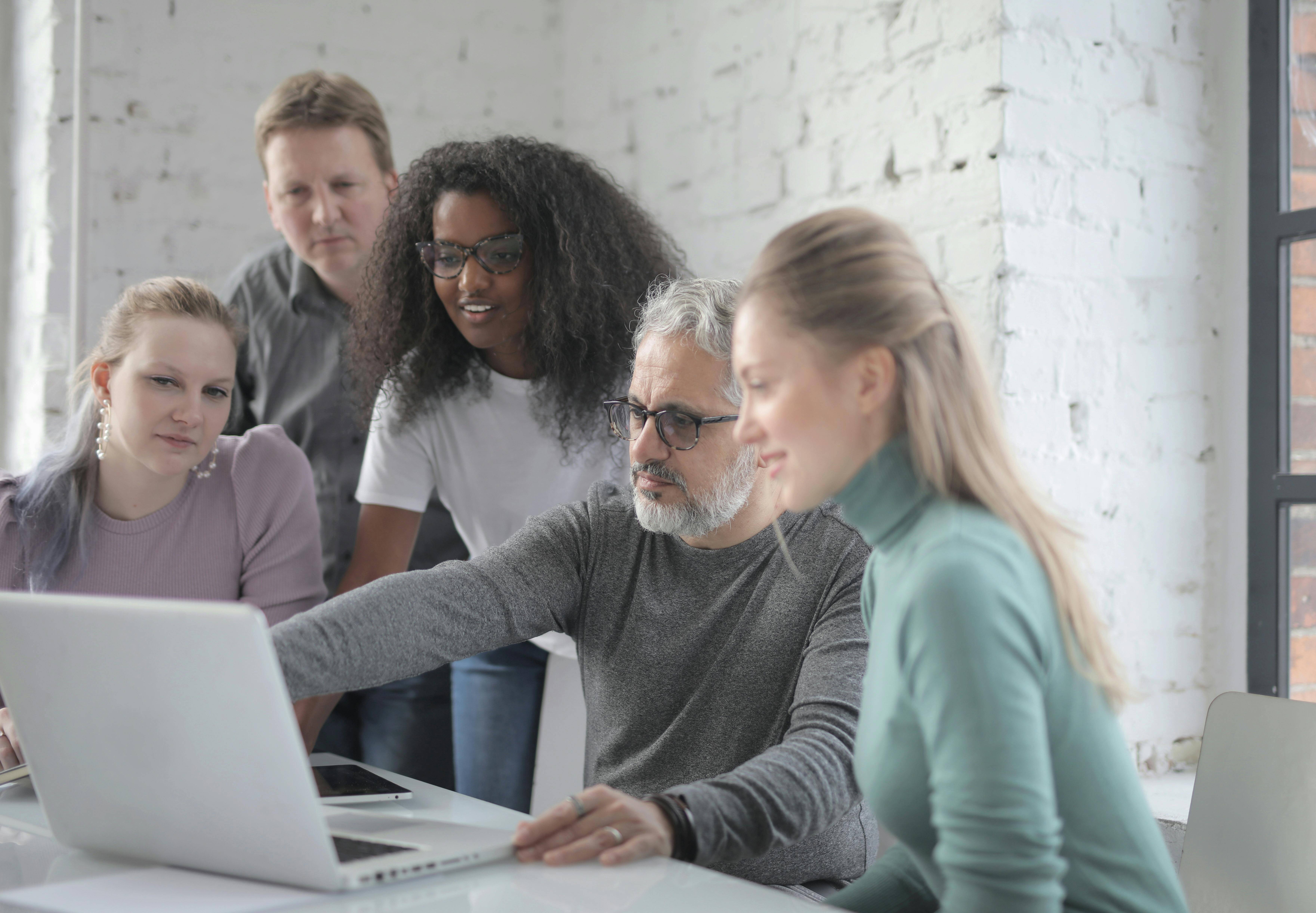 Group of colleagues around a laptop 