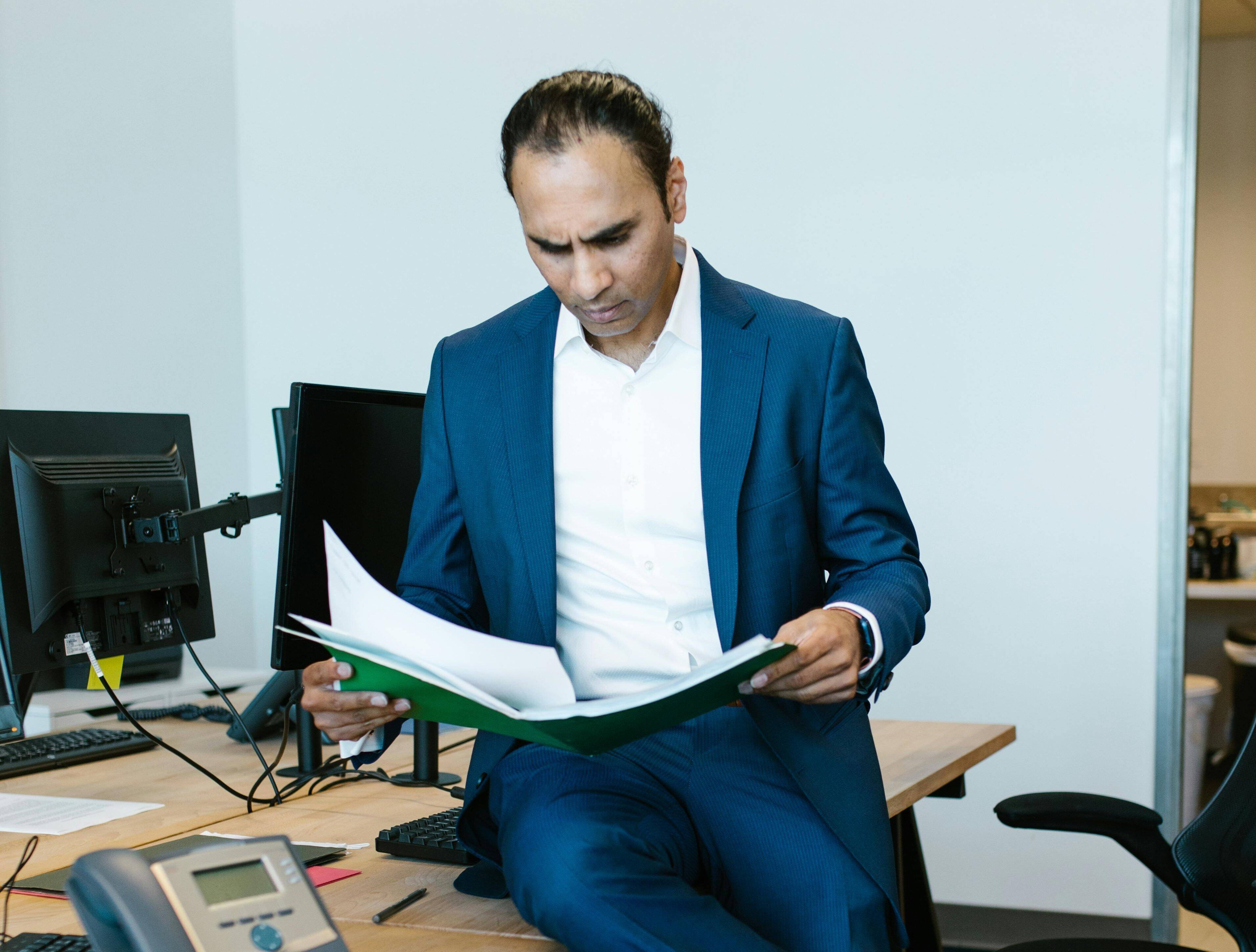 Man sat on a desk reviewing paperwork