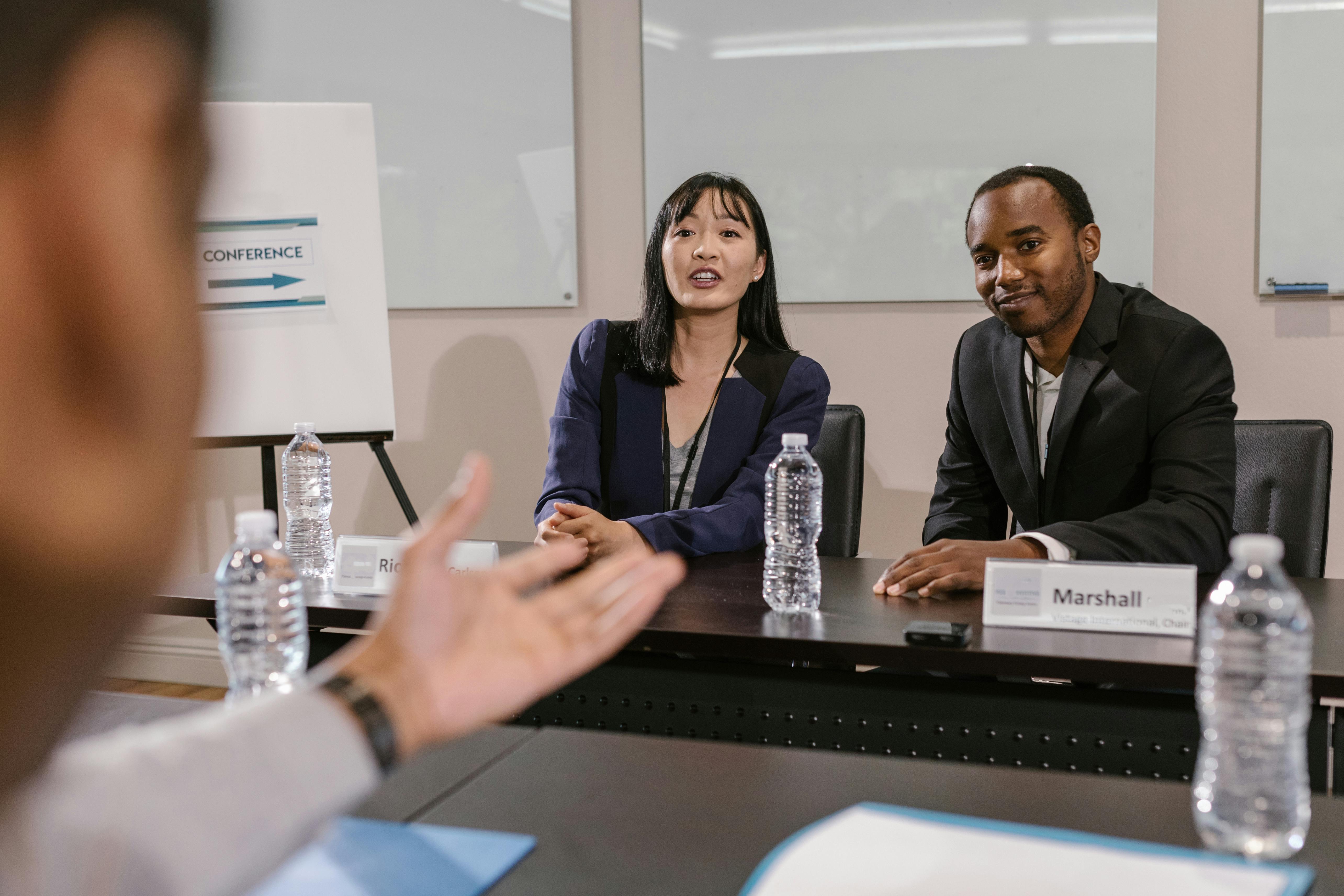 Man and woman sat behind a desk taking questions