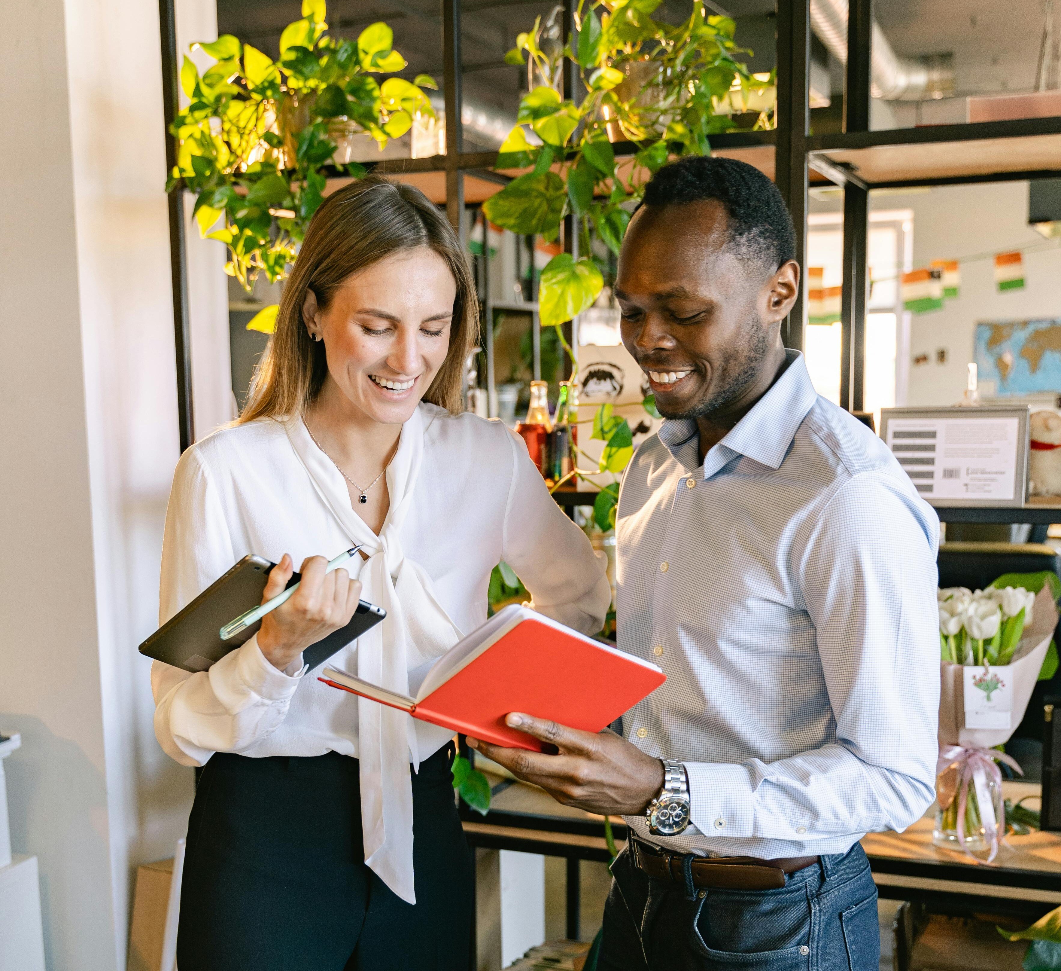 Corporate colleagues stood next to each other with notebooks, smiling