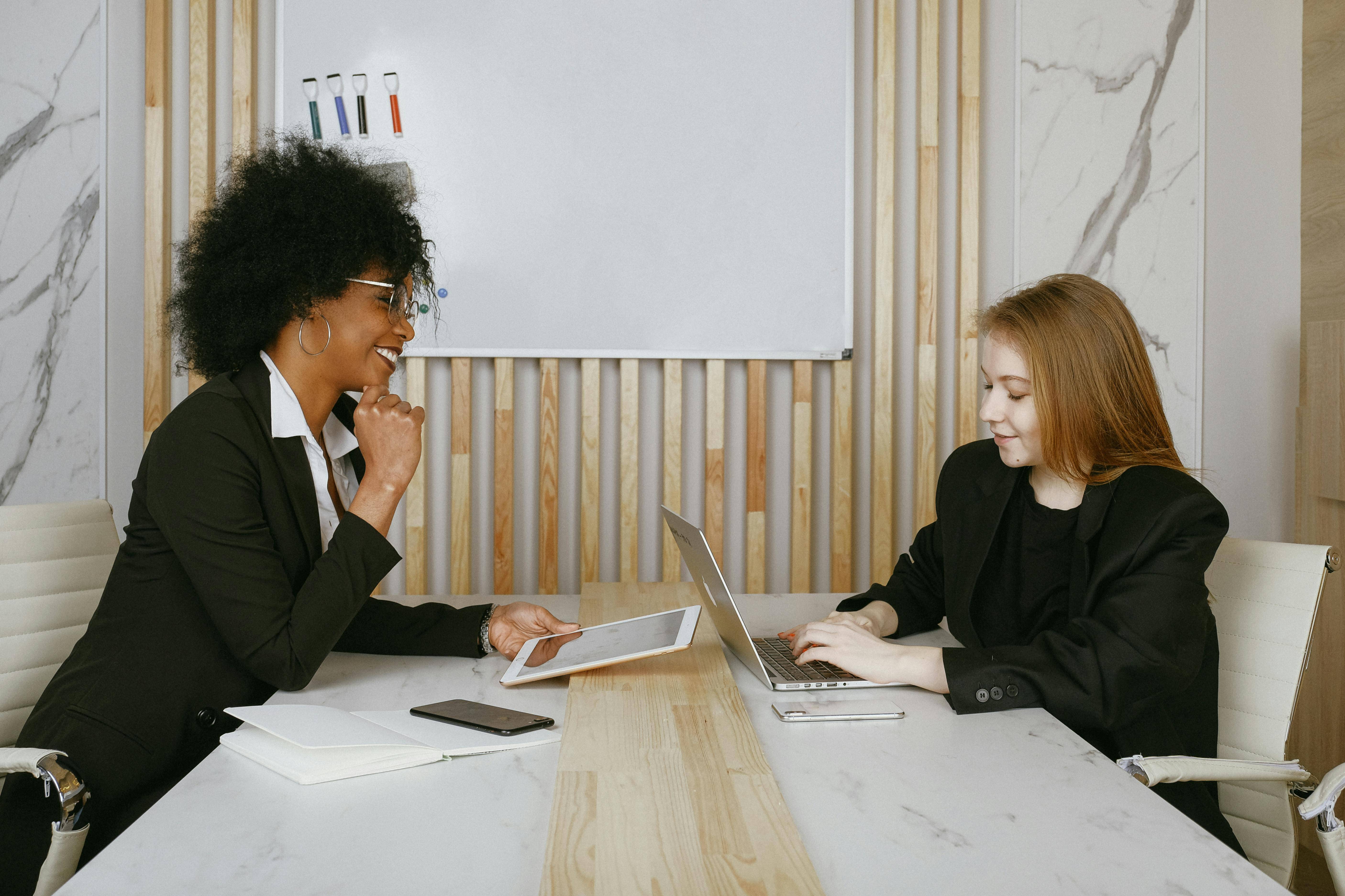 Two women sat either side of a desk