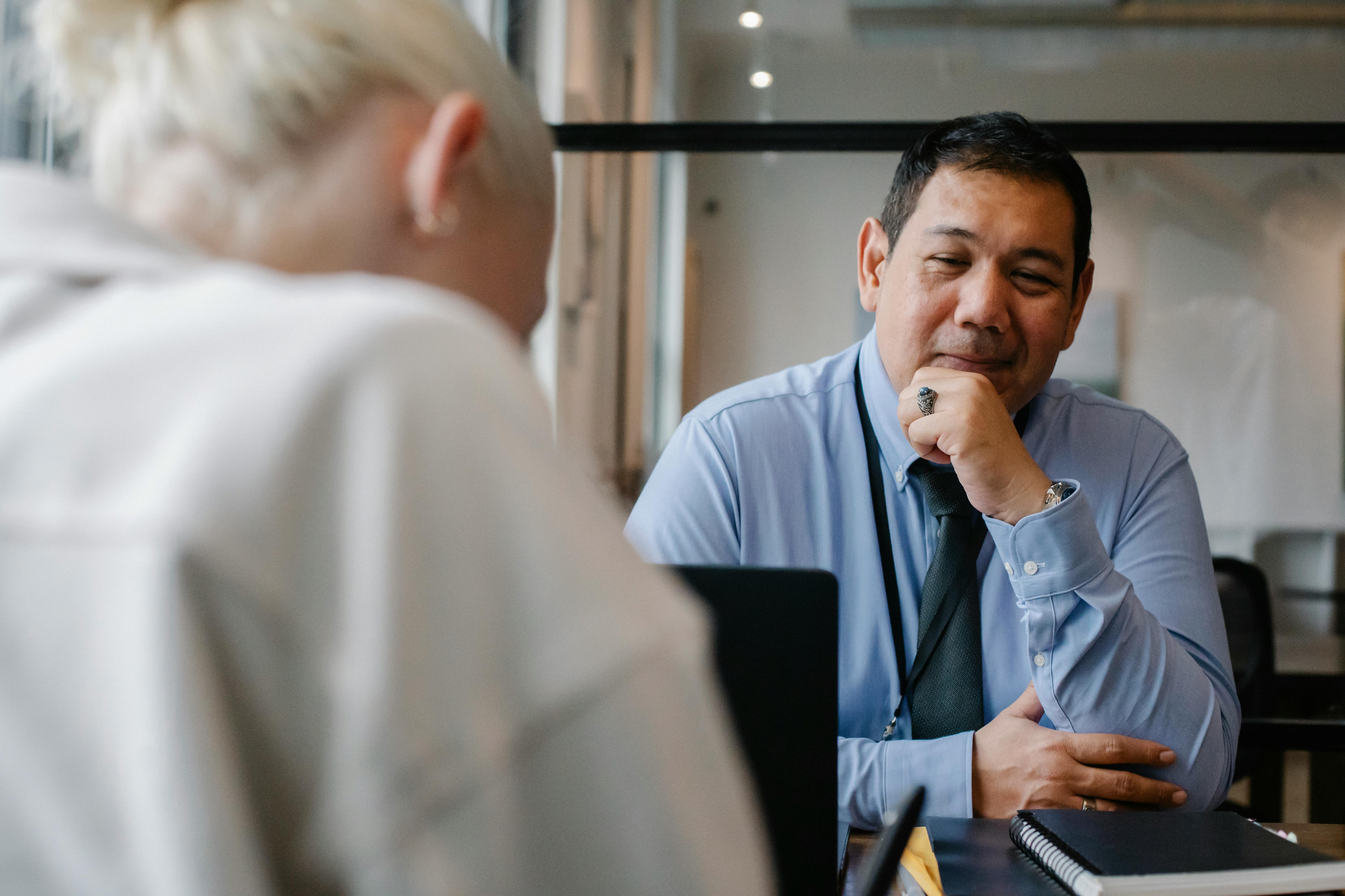 Man sat in front of a desk behind a laptop with a colleague on the other end